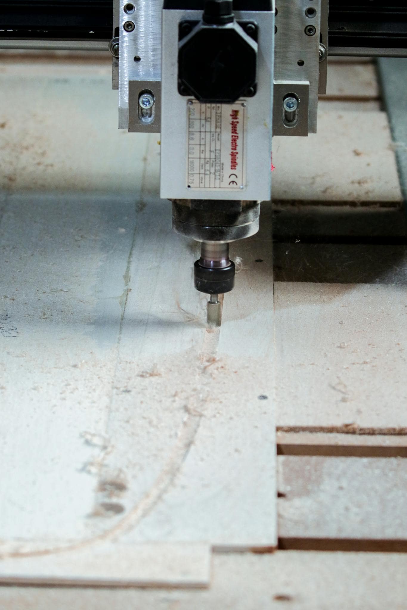 Close-up of a CNC milling machine precisely cutting wood in a carpentry workshop.