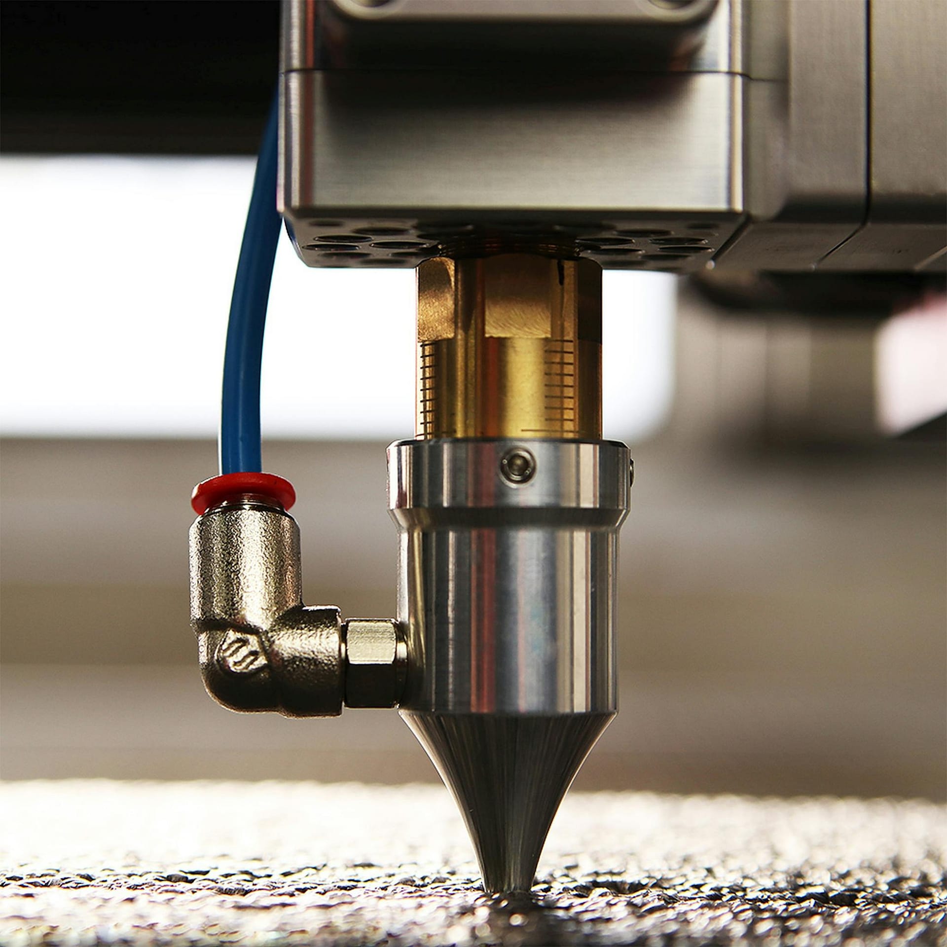 Detailed view of a CNC laser engraver in action, focusing on its precision nozzle.